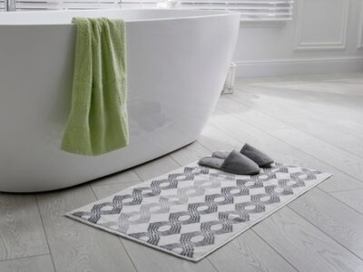 Stylish,mat,with,slippers,on,floor,near,tub,in,bathroom.